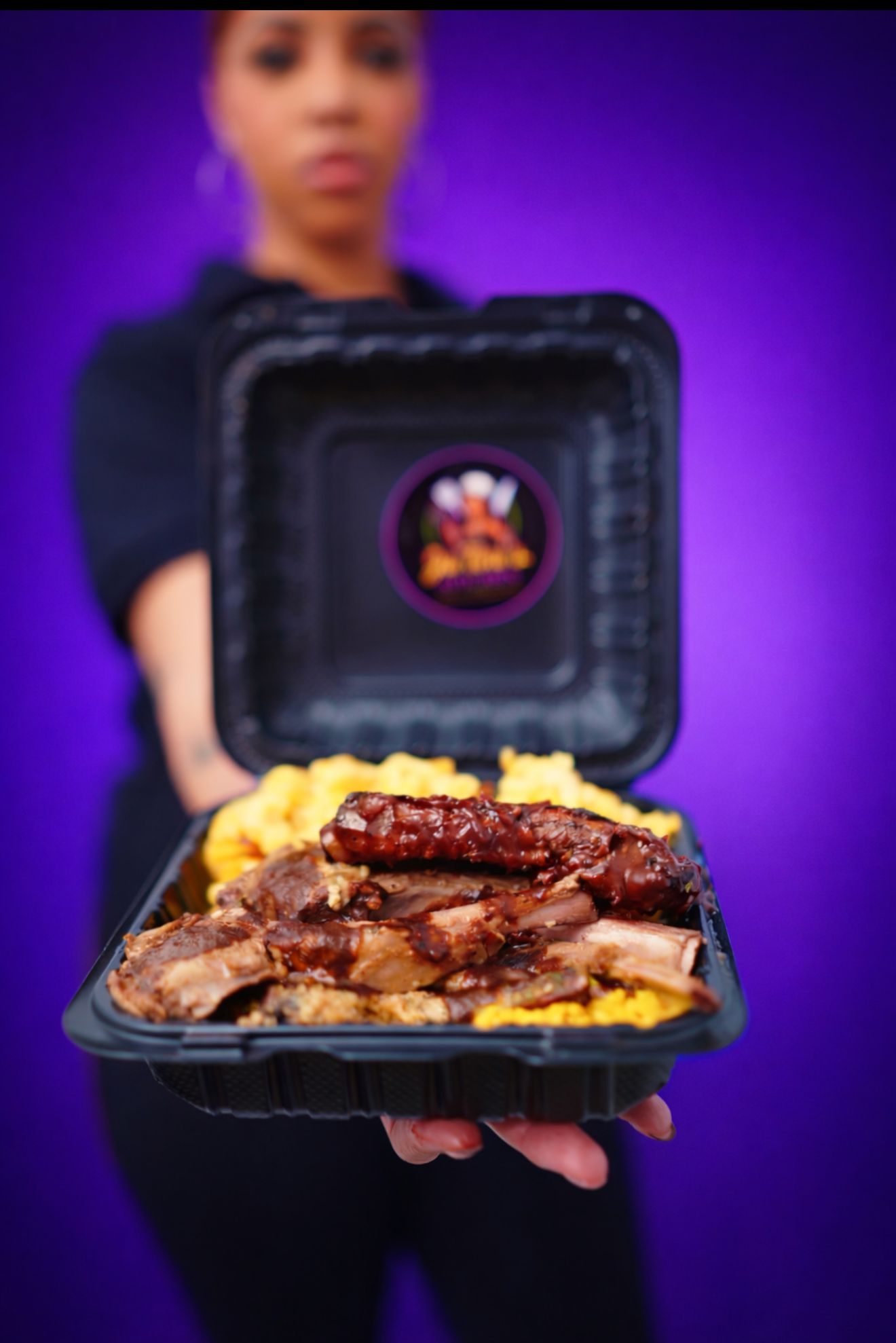 Ja Tori's Kitchen chef holding a platter of soul food that includes fried chicken